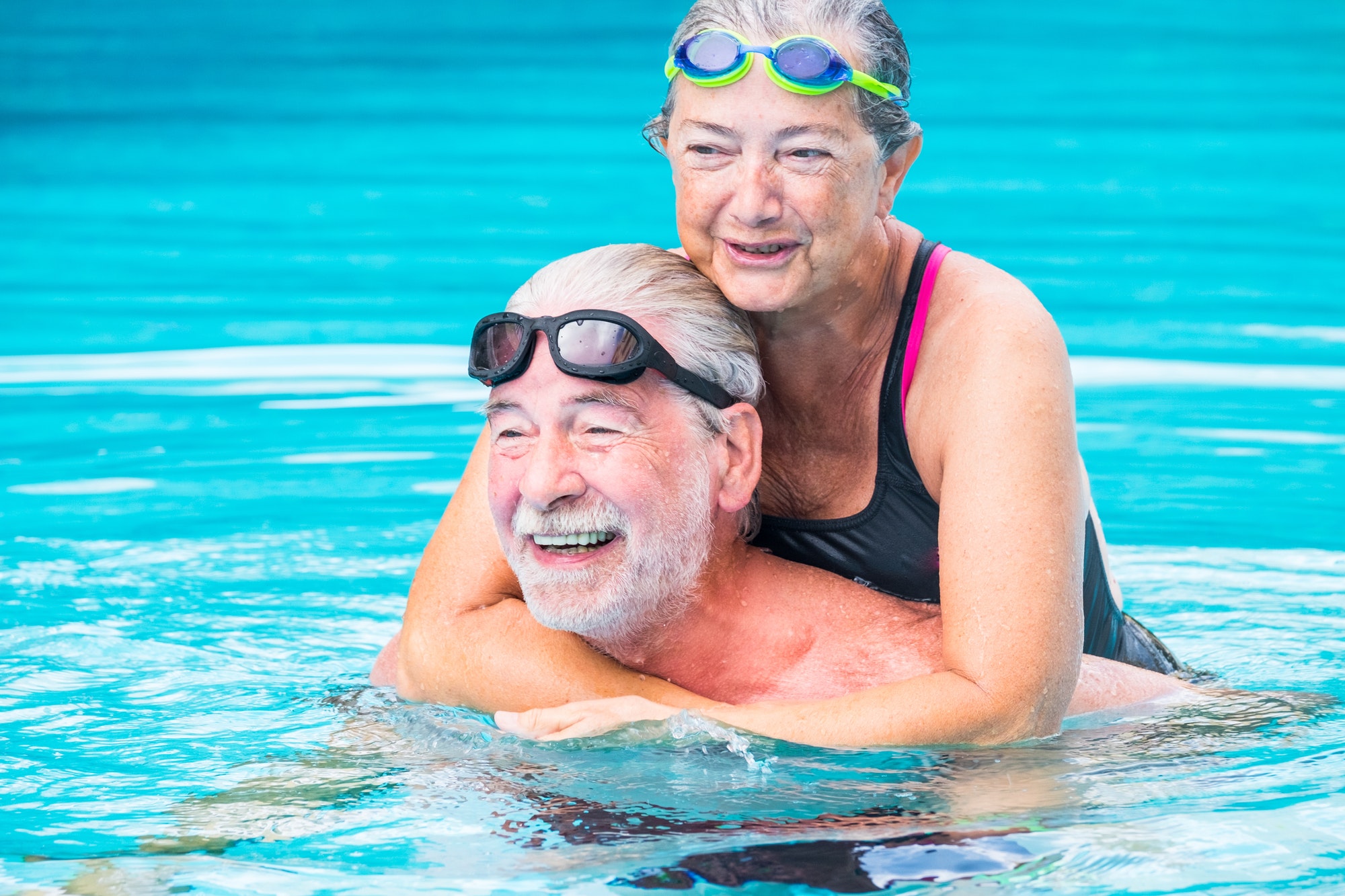 two pensioners or mature old people enjoying summer and vacations in the swimming together